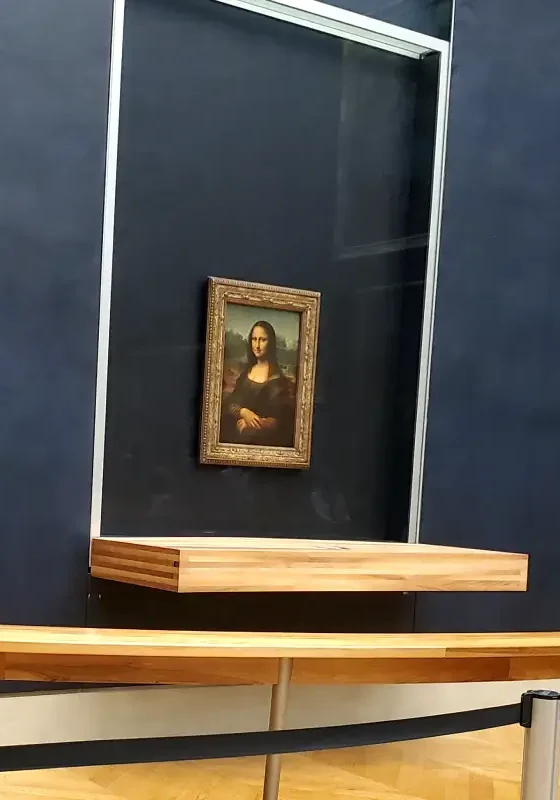 A painting of mona lisa on display in an art museum.